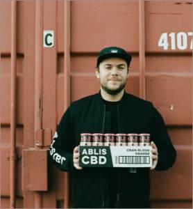 Man holding a case of Ablis cran-blood oragne